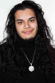 A man with long hair smiling into the camera