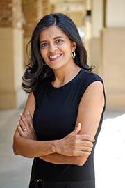A woman smiling at the camera with her arms crossed