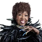 Woman wearing feather outfit and long blue nails on her hands.