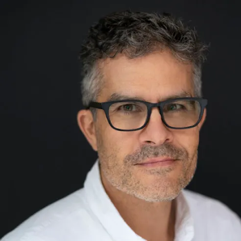Man wearing dark rimmed glasses and white button-up shirt.
