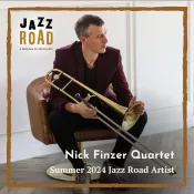 A man holding a trombone and looking to the side