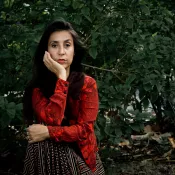 A woman looking into the camera and touching her face