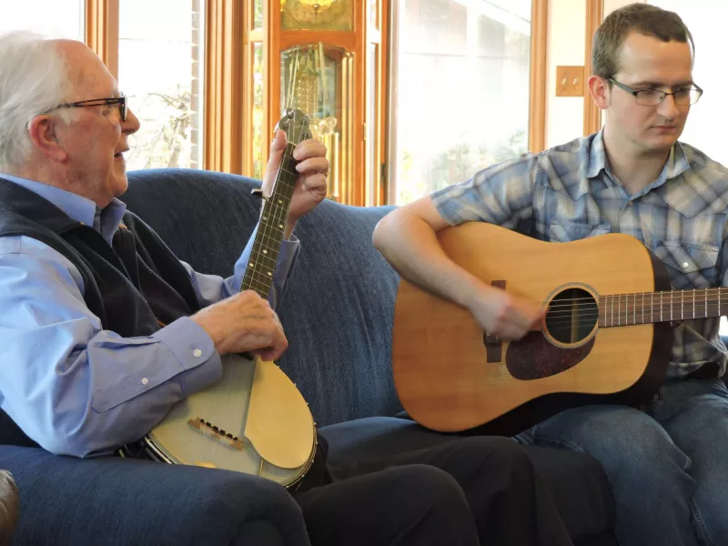 Playing banjo on sofa