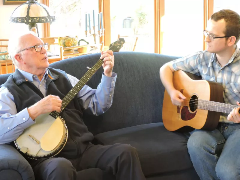 Playing banjo on sofa